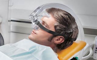 Sedierung bei einem Mann während der zahnärztlichen Behandlung mit Lachgas